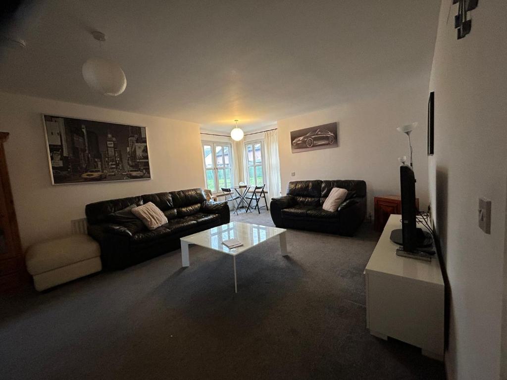 a living room with a couch and a table at Spacious Modern Apartment in St. Andrews