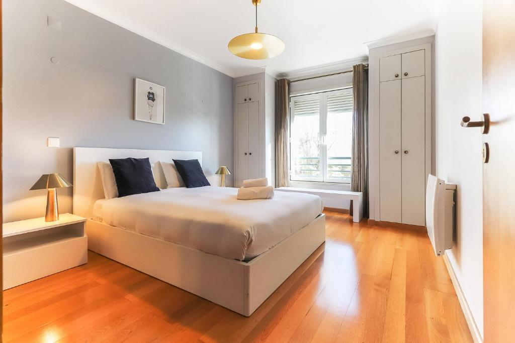 a bedroom with a large white bed and a window at Telheiras Premium by Homing in Lisbon