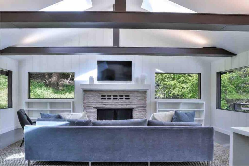 een woonkamer met een blauwe bank en een open haard bij Stunning Executive Retreat 5b/4ba —Entire Home in Portola Valley