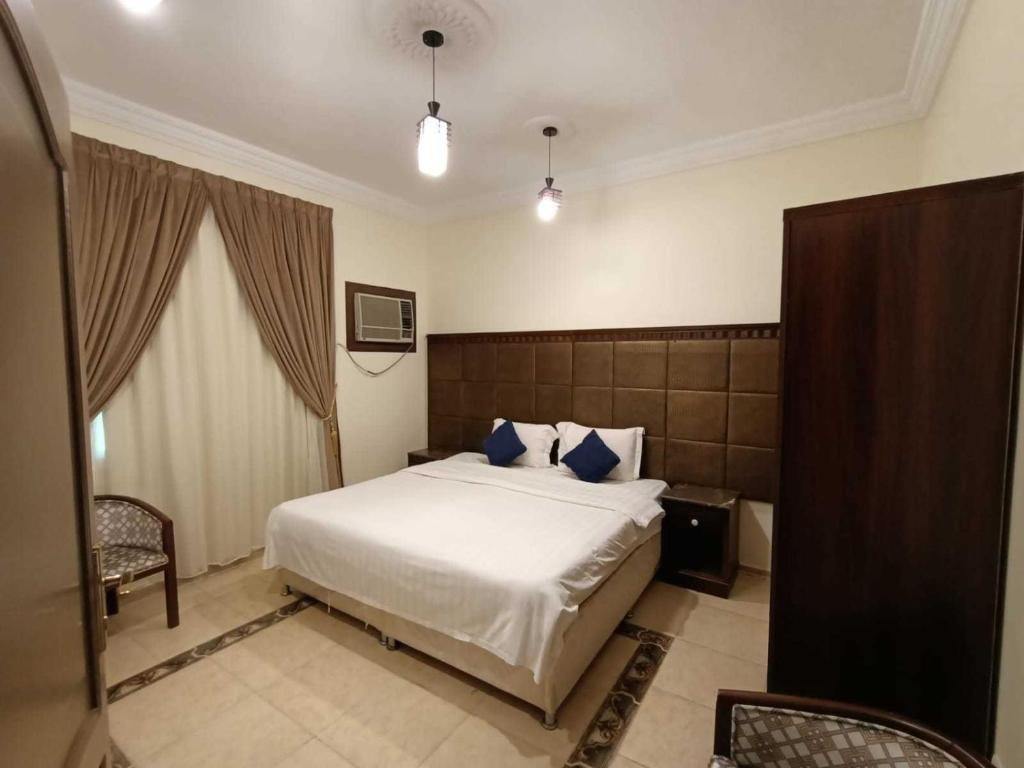 آفاق التميز في جدة: غرفة نوم بسرير كبير مع وسائد زرقاء