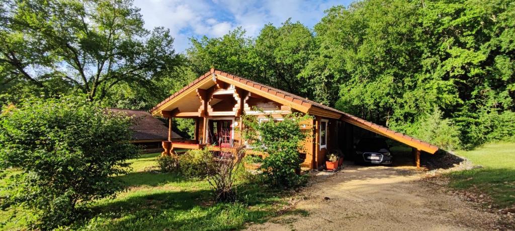 a house with a car parked outside of it at Le chalet Roy in Mauroux