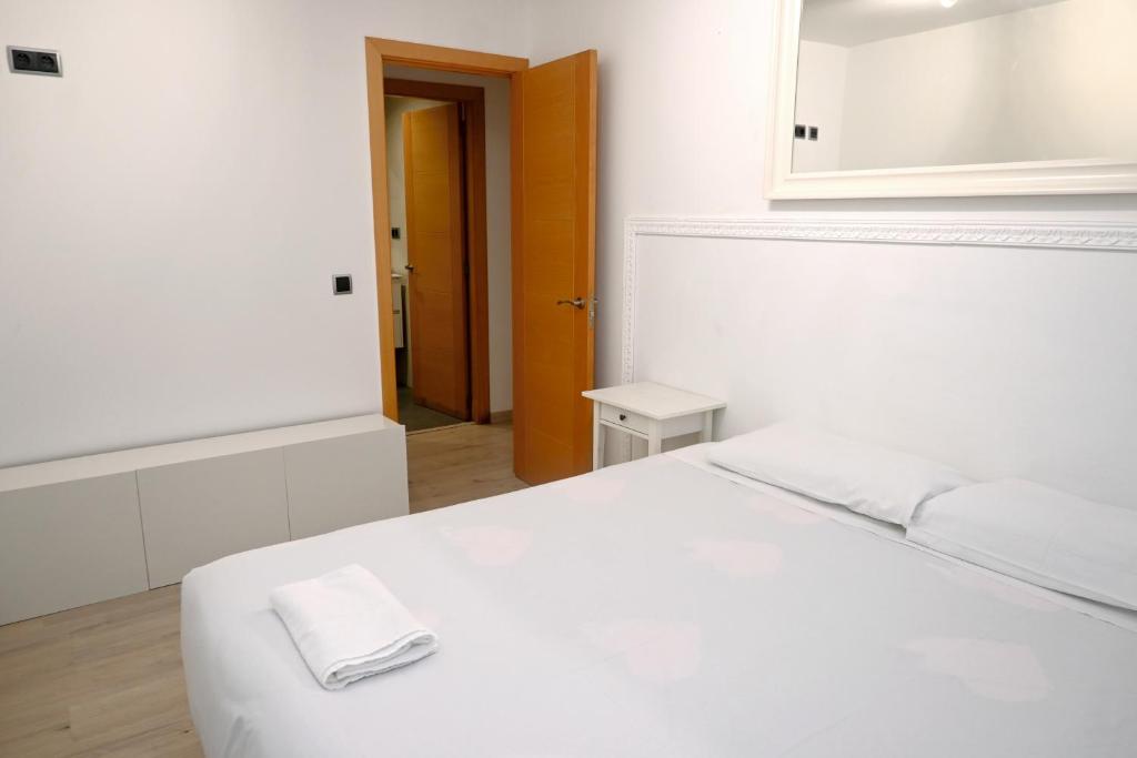 a white bedroom with a white bed and a mirror at Homenfun Barcelona Guinardó Hospital Sant Pau in Barcelona