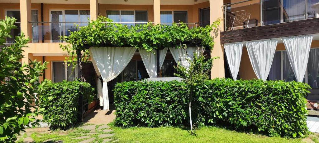 un giardino con tende bianche di fronte a un edificio di Sozopoli Hills Simeonov Apartments a Sozopol