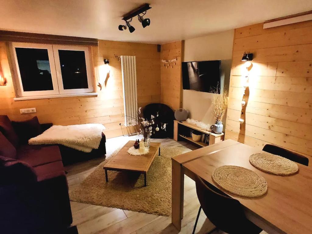 - un salon avec une table et un canapé dans l'établissement Joli Appartement Cosy 2 à 4 pers avec terrasse La Fourmi, à Orbey