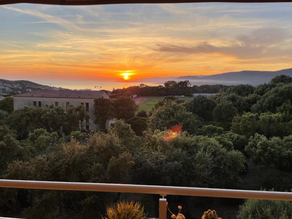 - un balcon offrant une vue sur le coucher de soleil dans l'établissement appartement Vue mer époustouflante, à Propriano