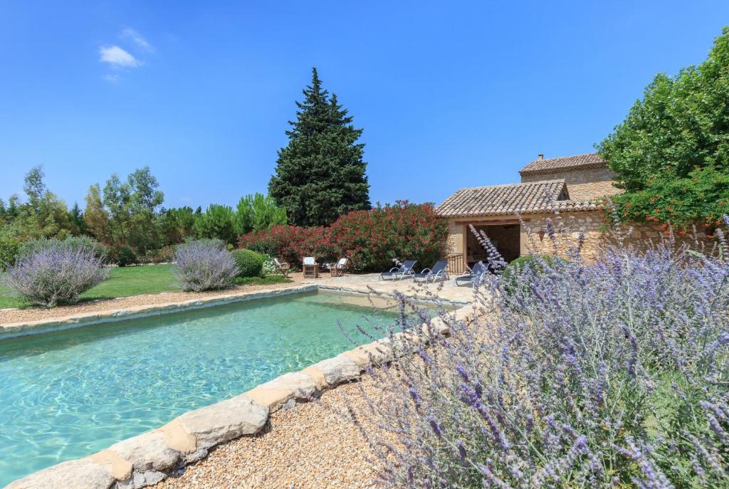 a swimming pool in the middle of a garden at La Louvière des Bruyères in Robion en Luberon