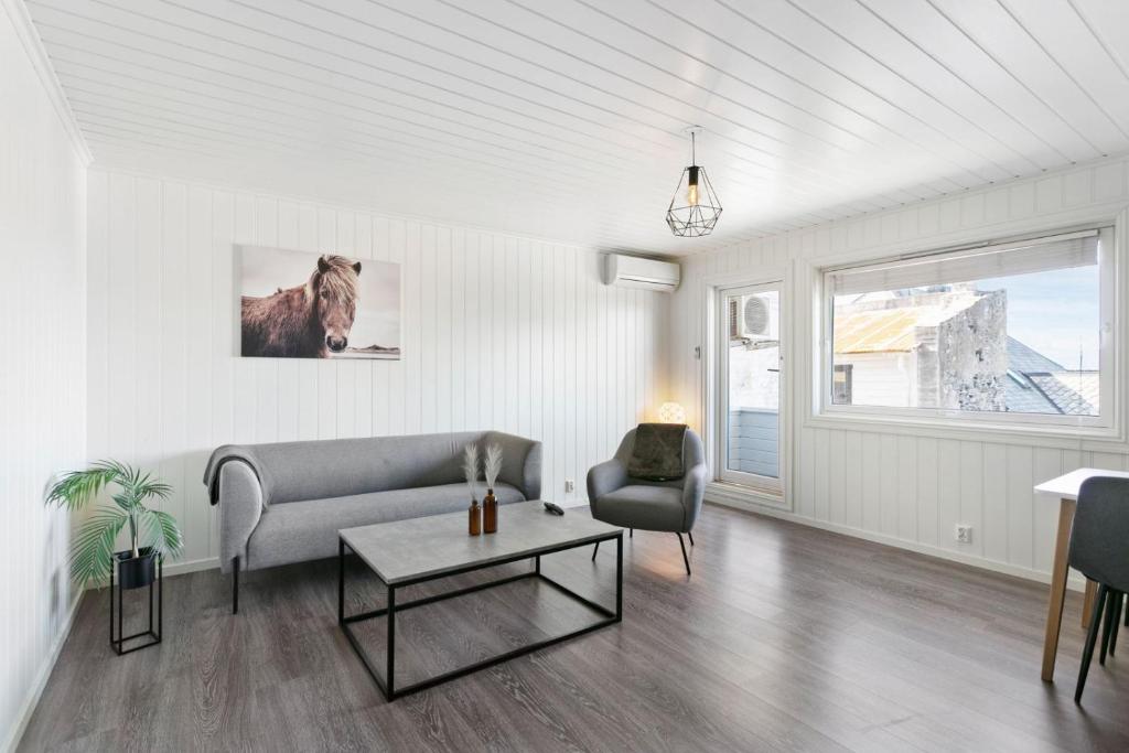 ein Wohnzimmer mit einem Sofa und einem Stuhl in der Unterkunft Centrum apartment in Ålesund