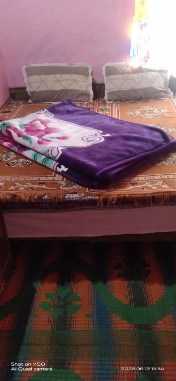 a purple blanket sitting on top of a bed at Sunflower in spiti kee in Kibar