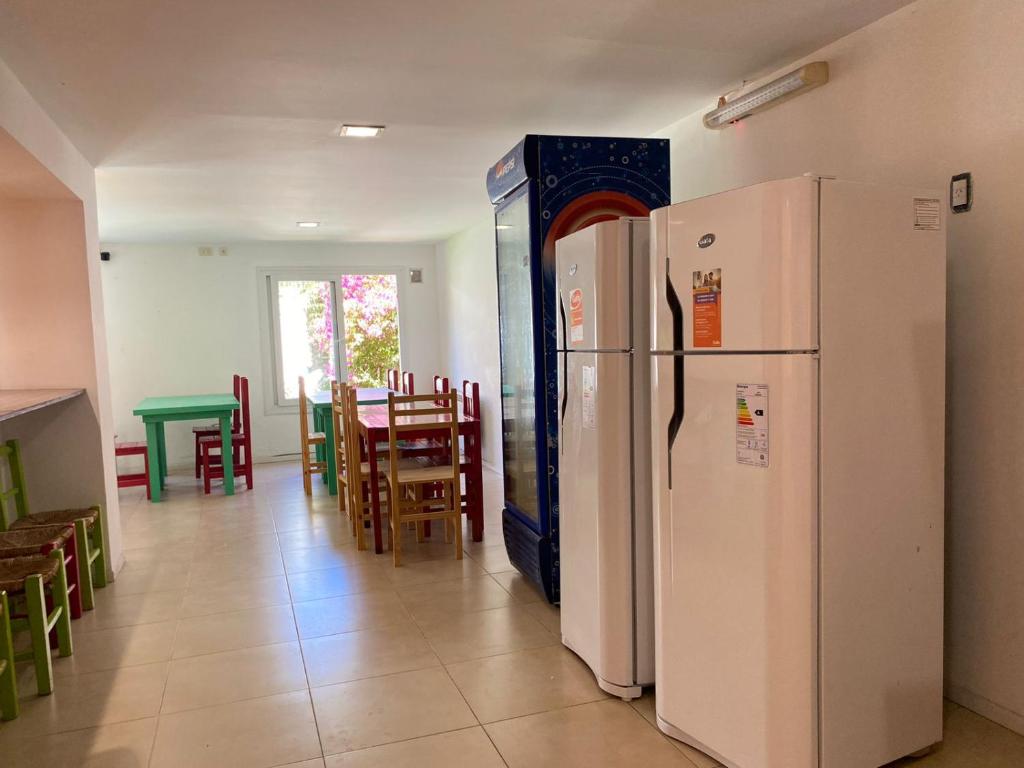 een keuken met 2 koelkasten en een tafel en stoelen bij Hostel Che Viajero in Villa Gesell