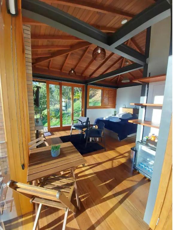 a living room with a table and a bedroom at Alto de Santa Barbara in São Francisco Xavier