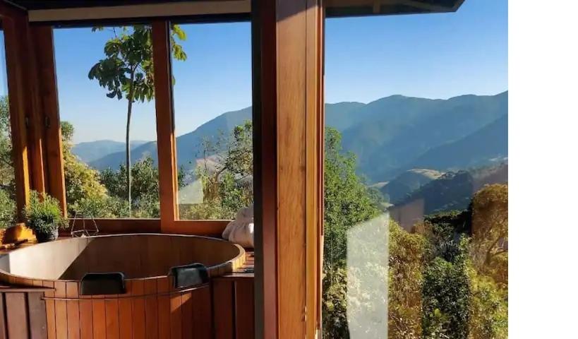 uma casa de banho com banheira e vista para as montanhas em Alto de Santa Barbara em São Francisco Xavier