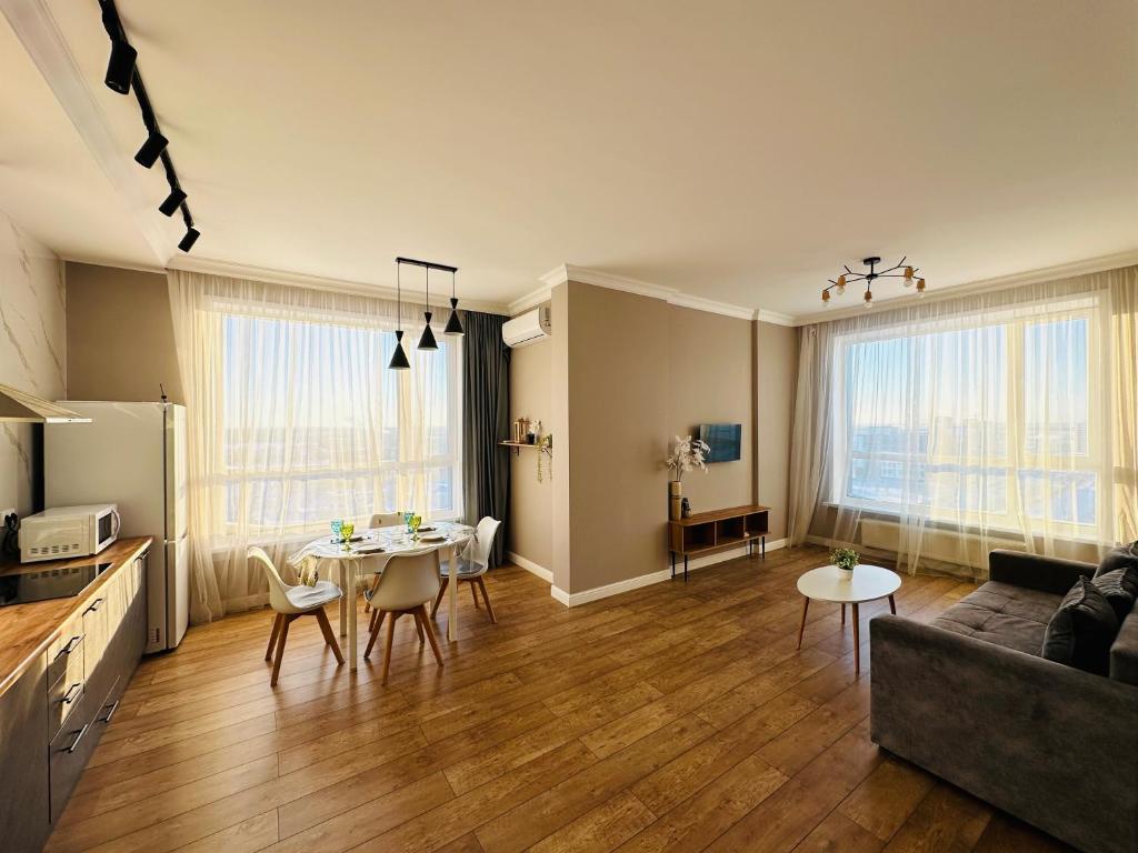 a living room with a table and a couch at Nexpo City 2-Room Apartments in Astana