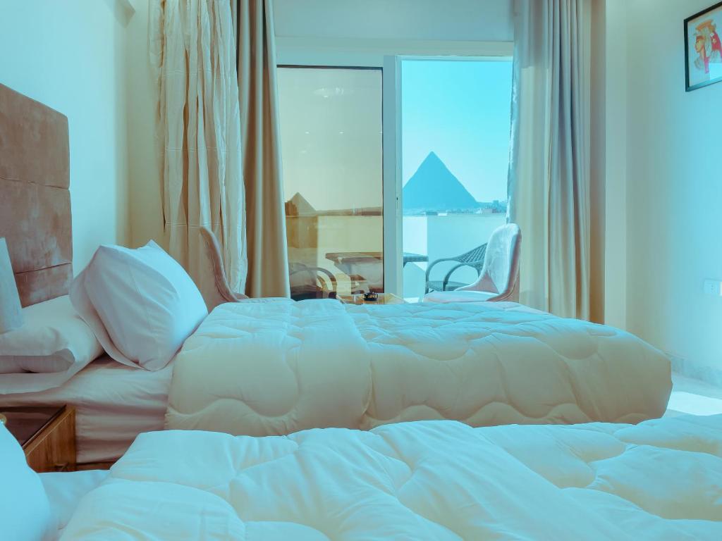 uma grande cama branca num quarto com uma janela em Pyramids Rose view no Cairo