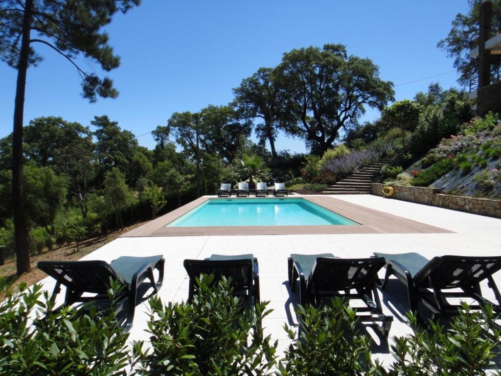 a swimming pool with chairs and a swimming pool at The Art House in Serra