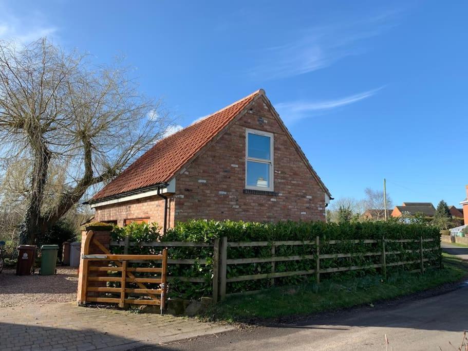 una casa de ladrillo con una valla de madera delante de ella en The Hideaway: Farnsfield (5 mins from Southwell) en Farnsfield