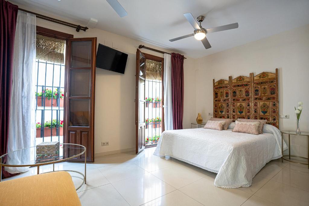 Schlafzimmer mit einem Bett, einem Tisch und Fenstern in der Unterkunft Casa la Mezquita con parking gratis in Córdoba
