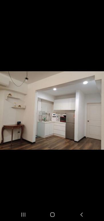 a large kitchen with white cabinets and a table at MAIN PLACE USJ21 SUBANG JAYA in Subang Jaya