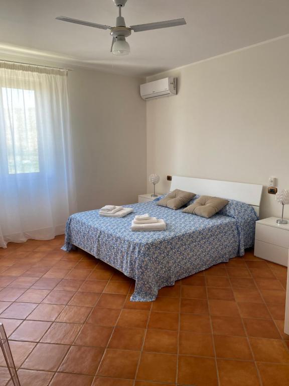 1 dormitorio con 1 cama y ventilador de techo en Baglio Quadrone bovo Marina, en Montallegro