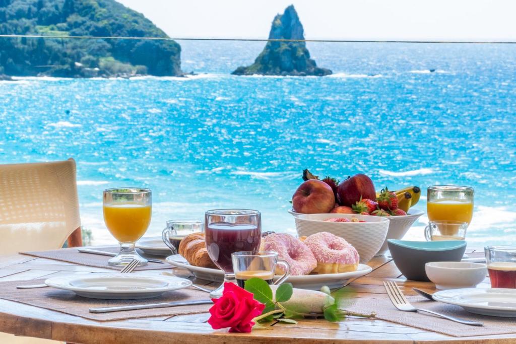 a table with food and a view of the ocean at Lido Paradise Apartments Corfu in Agios Gordios