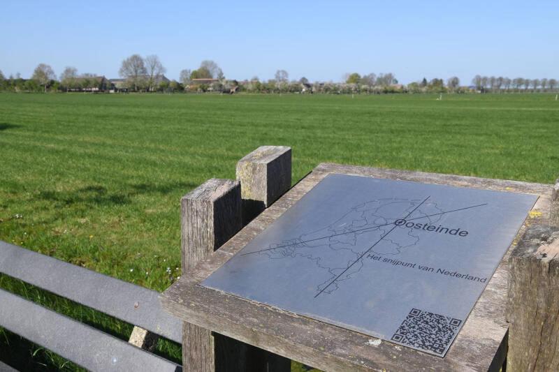 a sign on a bench with a field in the background at Appartement Ruinerwold in Ruinerwold