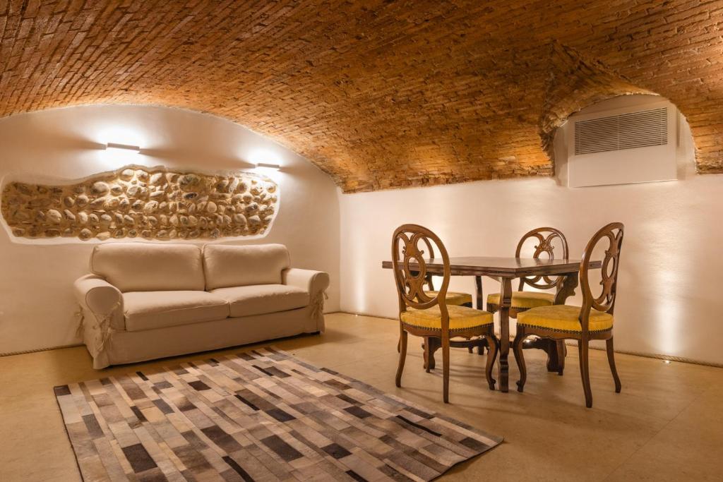 a living room with a table and chairs and a couch at Veronetta The Cellar in Verona