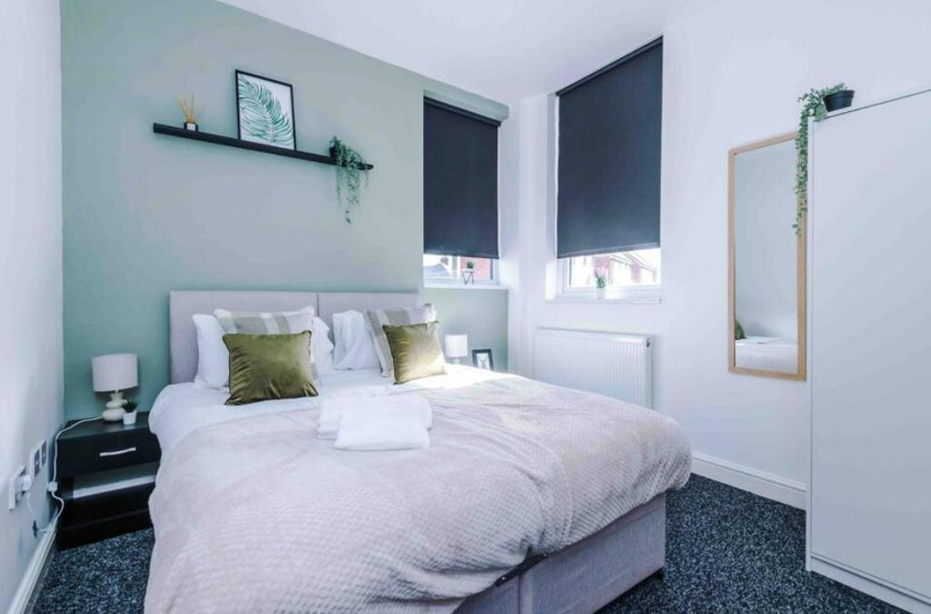 a bedroom with a large white bed with two windows at Spacious One-Bedroom Apartment in Saint Helens in Saint Helens