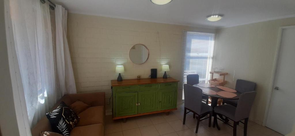 un salon avec une armoire verte et une table dans l'établissement Linda y acogedora casa en Coquimbo, à Coquimbo
