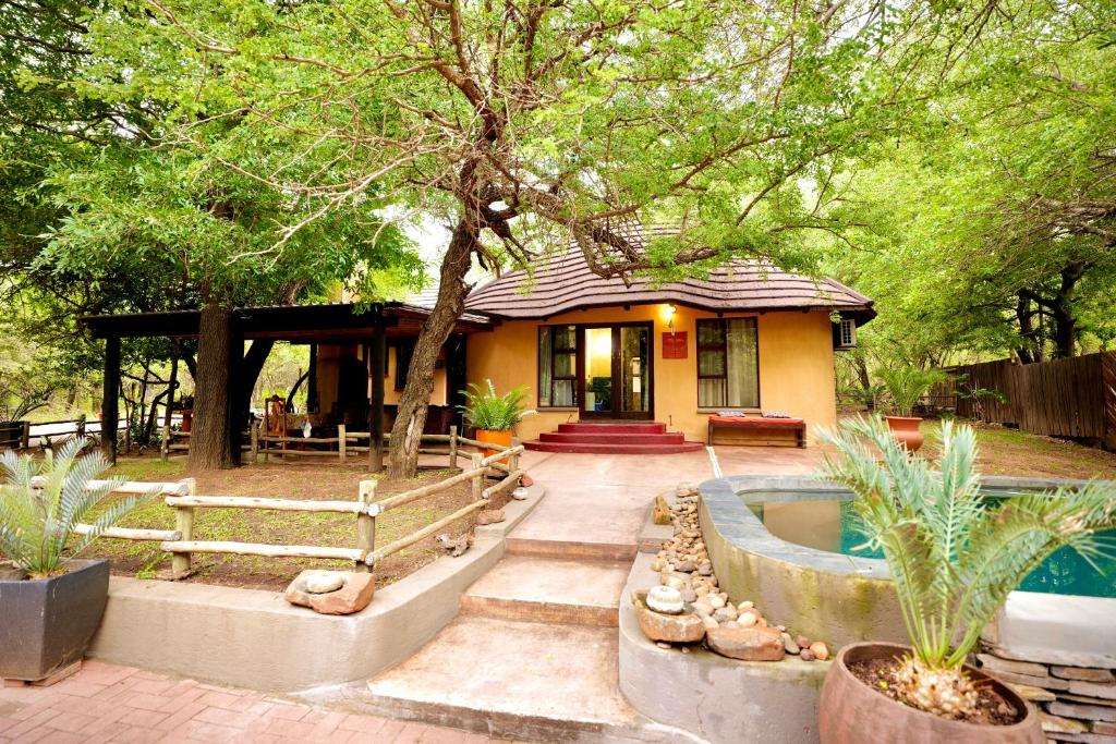 a house with a swimming pool in the yard at Hyenas Call in Marloth Park