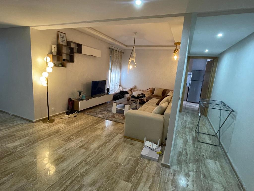 uma sala de estar com um sofá e uma mesa em Cosy & spacious apartment em Temara