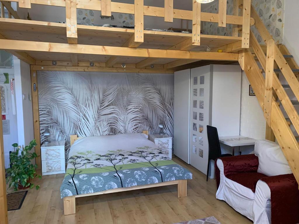 a bedroom with a loft bed with a mural on the wall at Város szíve apartman in Kaposvár