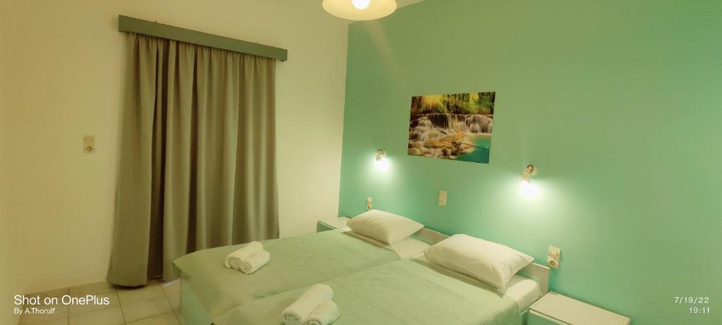 a bedroom with a bed with two pillows on it at MENTA APT in Agia Pelagia