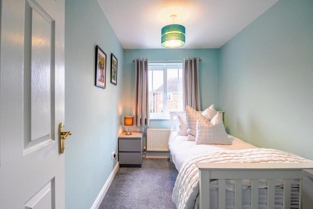 een kleine slaapkamer met een bed en een raam bij Charming 3 Bedroom, 2 Bathroom Home in Northampton - SKY TV included, Free Parking & WiFi by HP Accommodation in Northampton