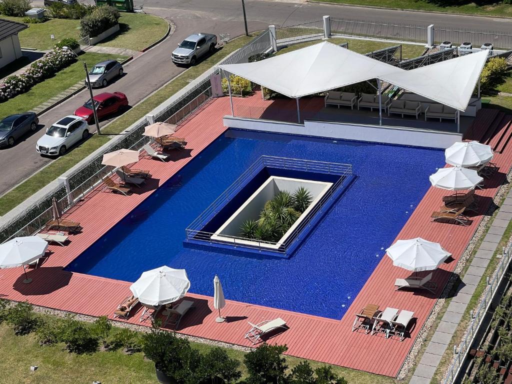 an overhead view of a swimming pool with chairs and umbrellas at Punta del Este - Green Life - Top amenities in Punta del Este