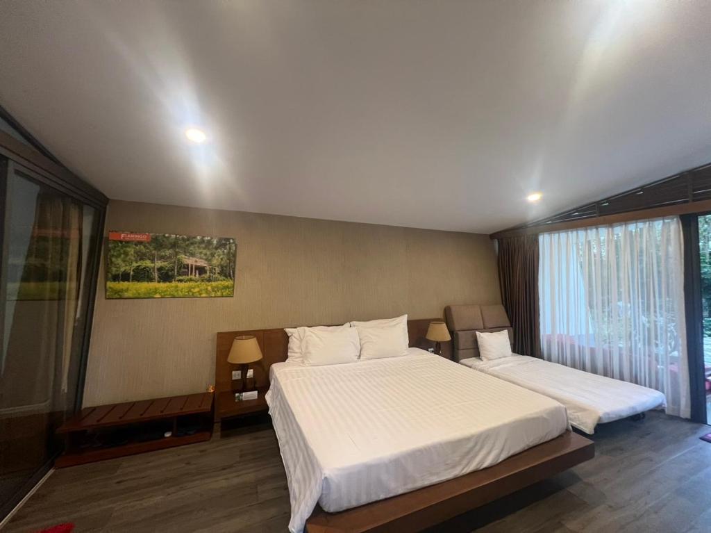 1 dormitorio con 2 camas y ventana grande en Forest Villa 330 Flamingo Dai Lai, en Ngọc Quang