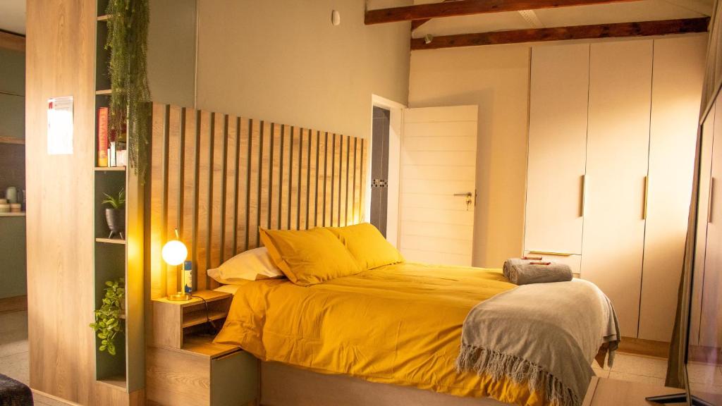 a bedroom with a bed with a yellow blanket at Leipoldt Self-Catering Apartment in Secunda