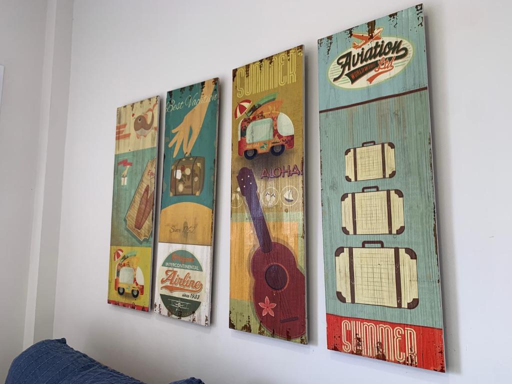 cuatro carteles colgando en una pared en Apartamento La Vasca en El Puerto de Santa María