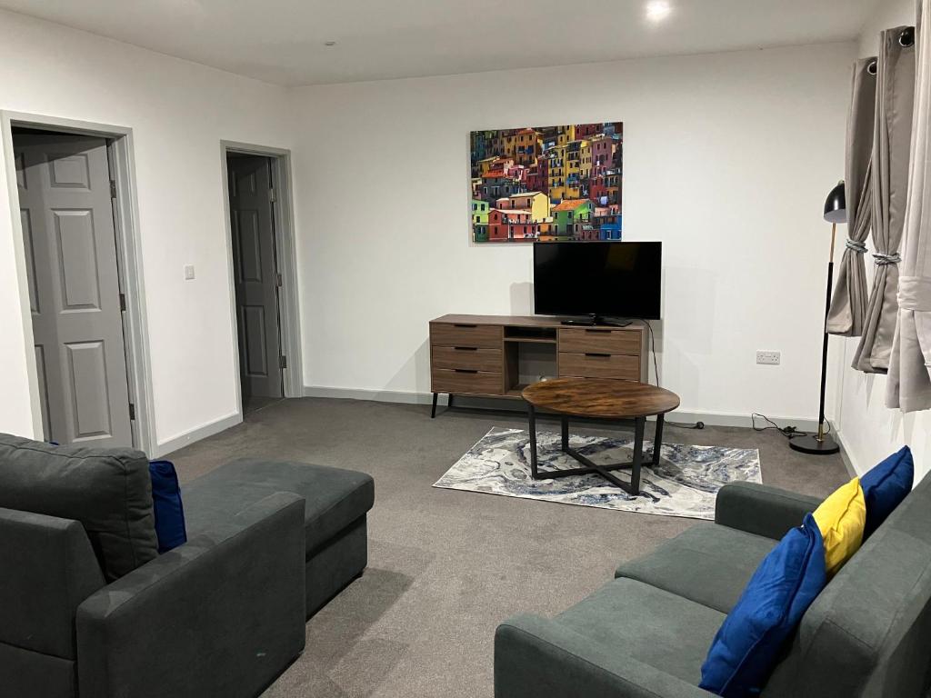 a living room with two couches and a tv at Lancing Apartments 2 Bedrooms, Sleeps 5 to 6 First floor Slough M4 Legoland in Slough