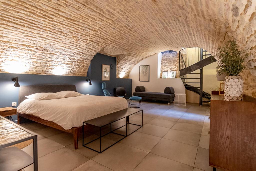 a bedroom with a bed and a brick wall at La chouette d'or in Dijon