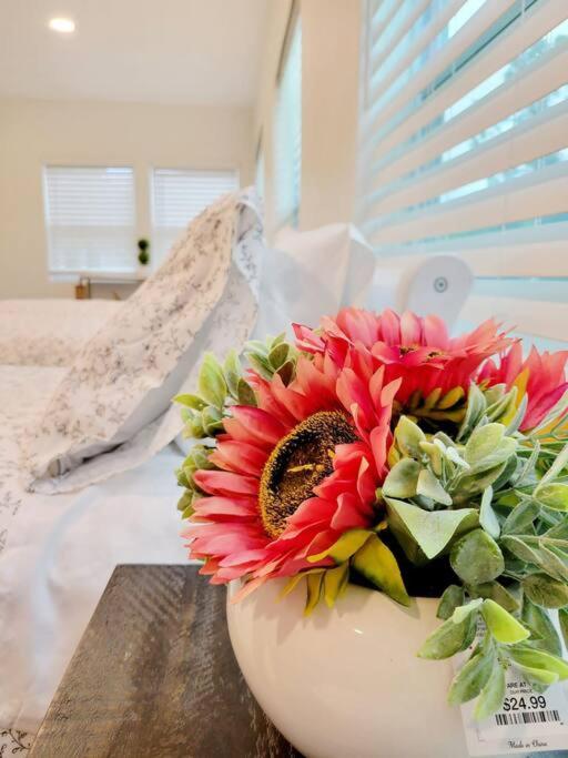 a bouquet of red flowers in a white bowl on a table at The Retreat #8231 in West Palm Beach