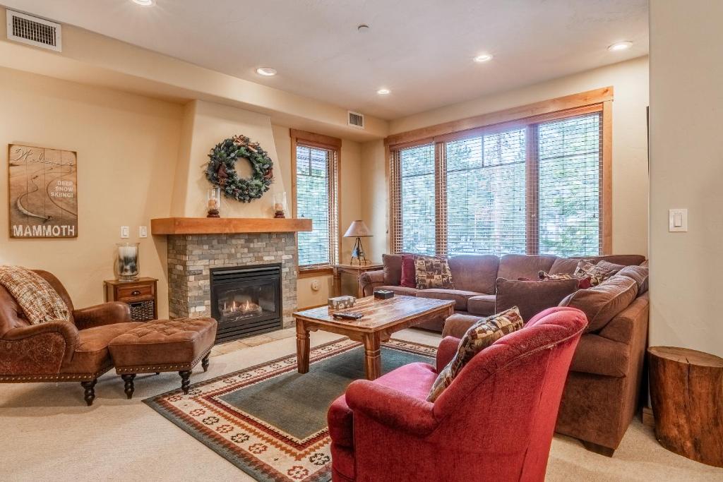 Una sala de estar con sofás y chimenea. en Upscale 4 Bed, 3 Bath at the Woodwinds with Amazing Mountain Views and Golf Course Access and private hot tub and garage sleeps 10, en Mammoth Lakes