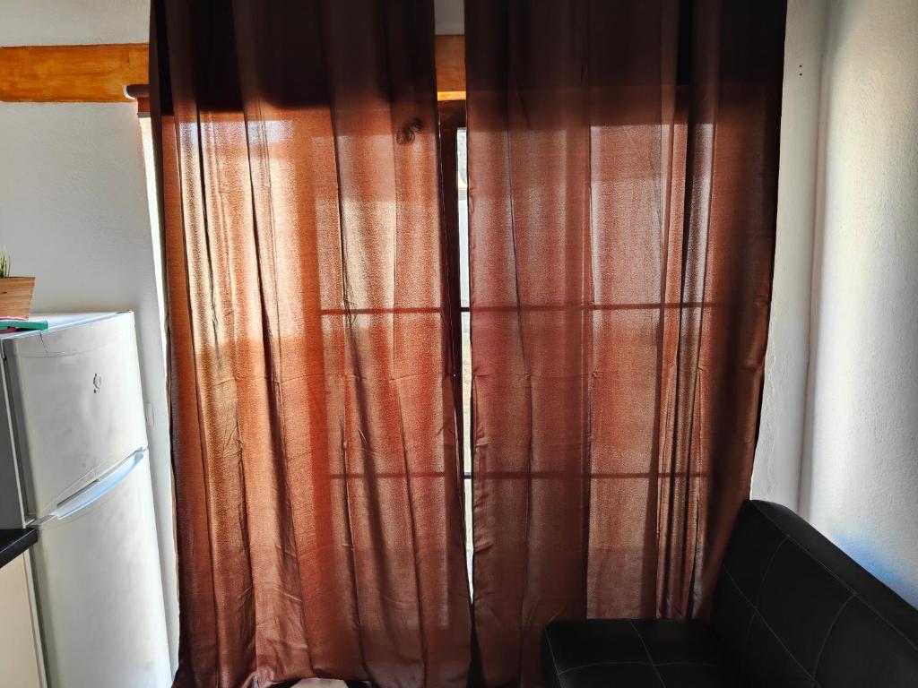 a brown curtain in a room with a refrigerator at Loft la Caletilla in Caleta de Sebo