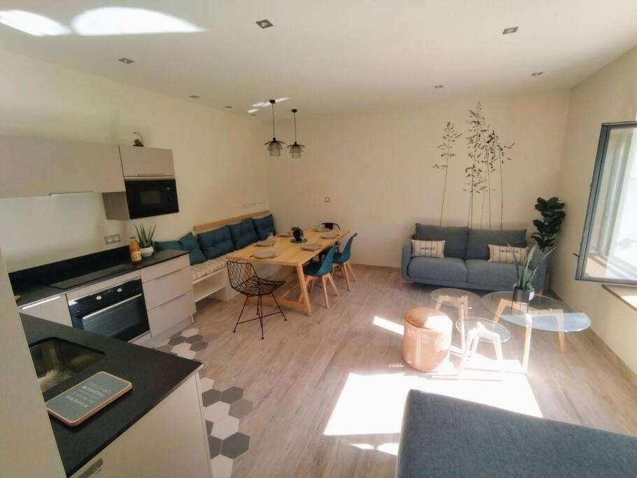 孔卡尔诺La Maison de Tante Yvonne - Gîte de Kerblaise的一间厨房和一间带桌椅的客厅