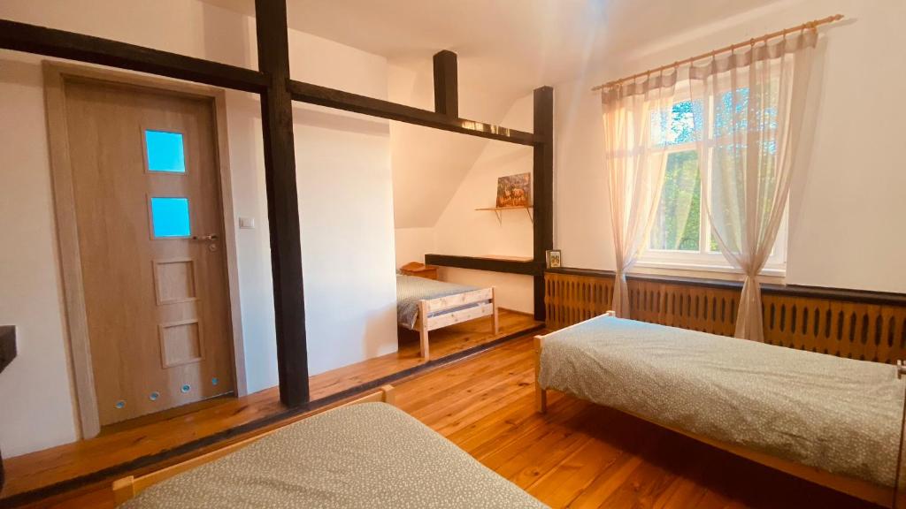 1 dormitorio con 2 camas y ventana en Rykowisko - Agroturystyka dla dorosłych, 