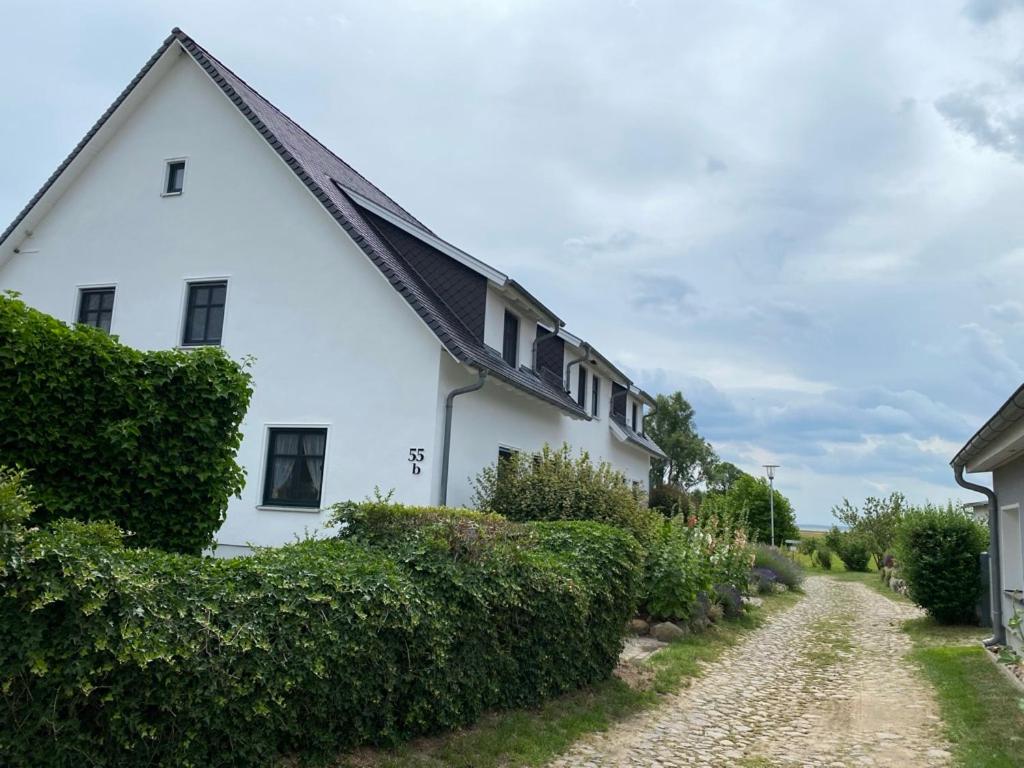 a white house with a gravel road in front of it at Ferienwohnung Groß Zicker in Groß Zicker