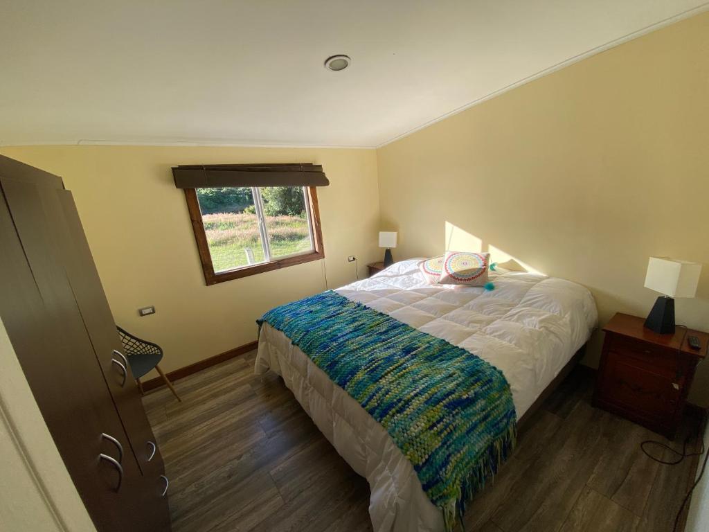 een slaapkamer met een bed en een raam bij Cabañas Nalhuitad in Molina