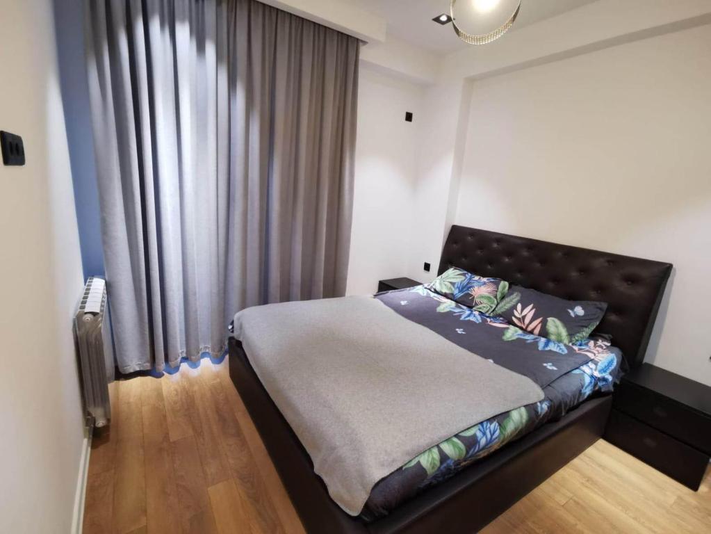 Schlafzimmer mit einem Bett und einem großen Fenster in der Unterkunft Tina Apartment N64 in Agaraki