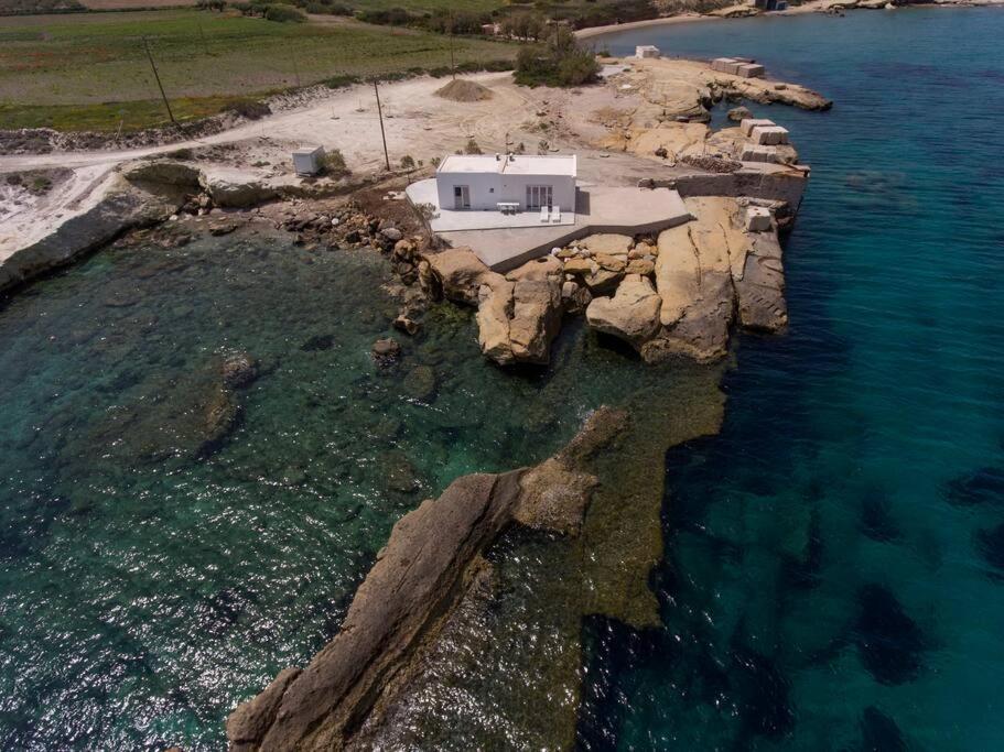an aerial view of a house on a rocky island in the water at Poseidon House in Pollonia