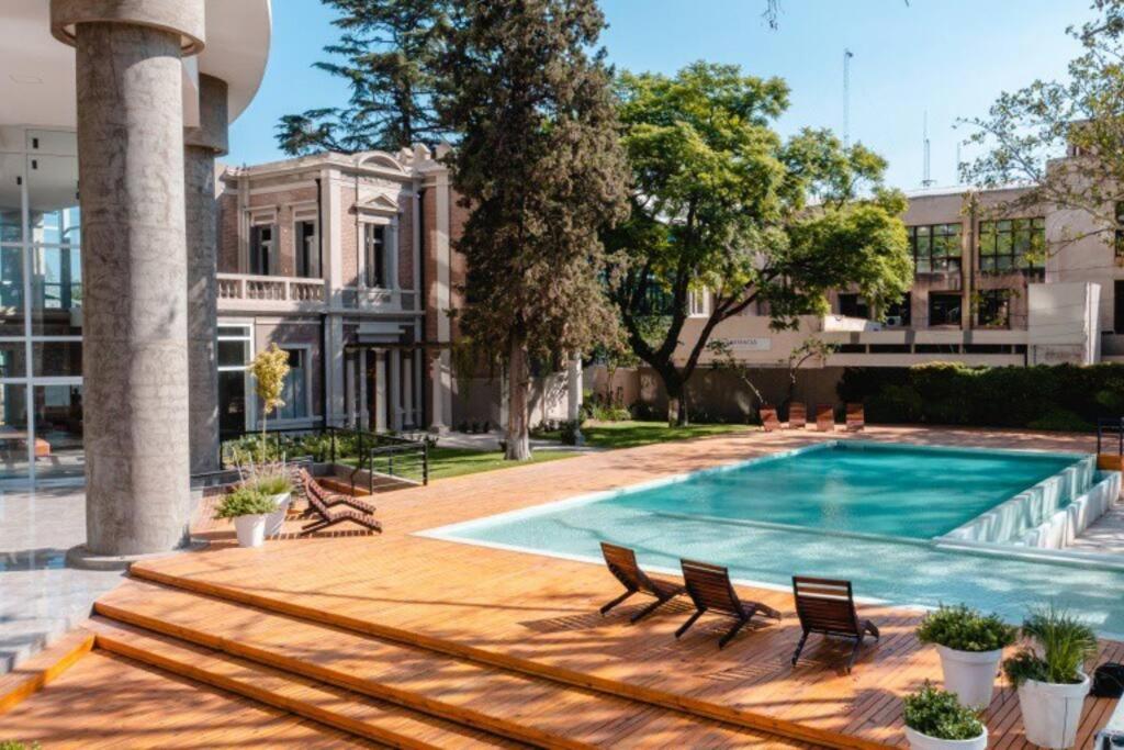 門多薩的住宿－Excelente depto en Torre Leloir，一座带椅子的游泳池以及一座建筑