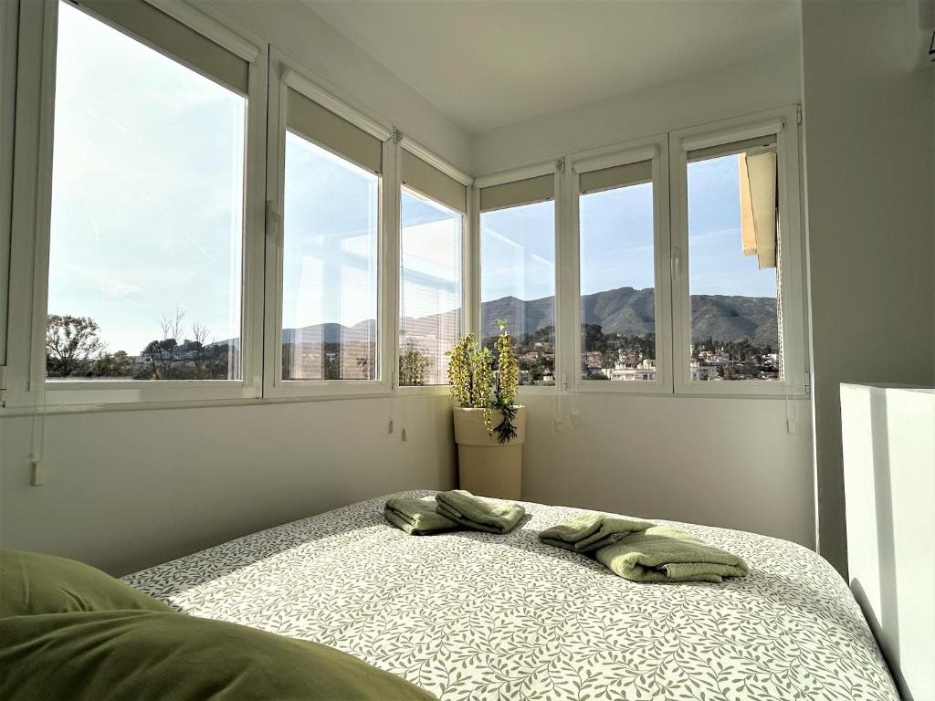 1 dormitorio con 1 cama y ventanas con vistas a las montañas en Green Hill 435, en Torremolinos