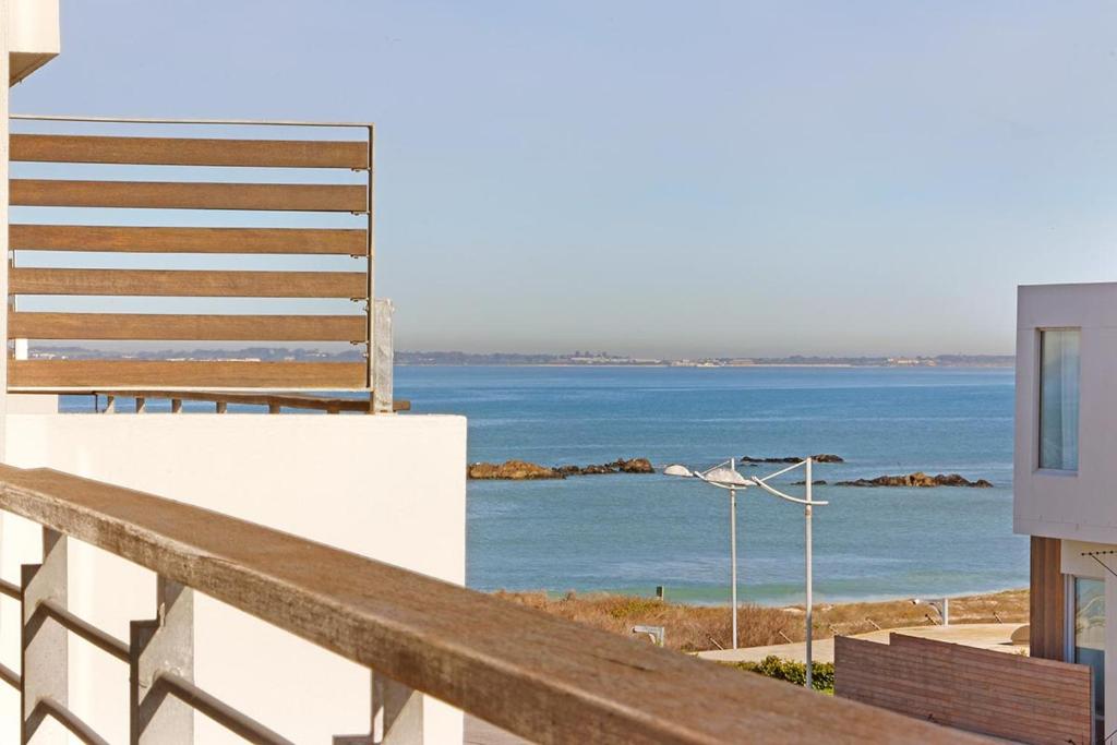a view of the ocean from the balcony of a building at Eden On The Bay 172 by HostAgents in Bloubergstrand